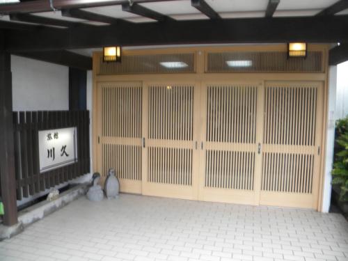 an entrance to a building with a large wooden door at Family Ryokan Kawakyu with Showa Retro, private hot spring in Ibusuki