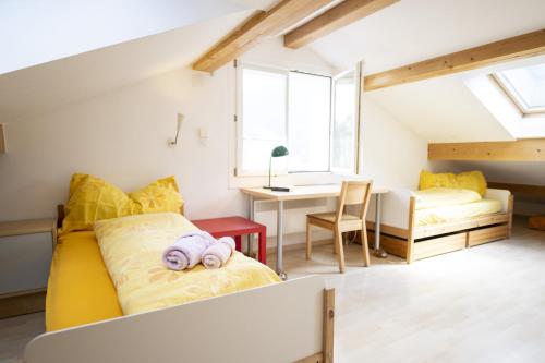 ein Schlafzimmer mit einem gelben Bett und einem Schreibtisch in der Unterkunft Feriensiedlung Trü 17 in Scuol
