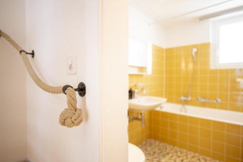 a bathroom with a door with a rope on it at Feriensiedlung Trü 17 in Scuol