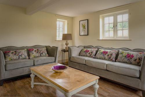 a living room with two couches and a coffee table at Brook Cottage in Kelling