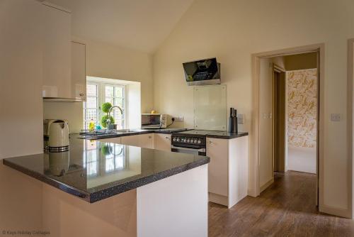 a kitchen with white appliances and a counter top at Brook Cottage in Kelling