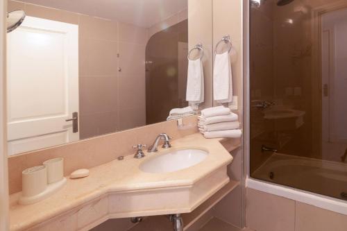 a bathroom with a sink and a mirror and a tub at Oceana Suites en Green Park, playa Solanas in Punta del Este