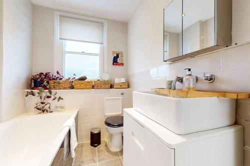 a white bathroom with a sink and a toilet at Stunning 1 bed apartment in Fulham in London