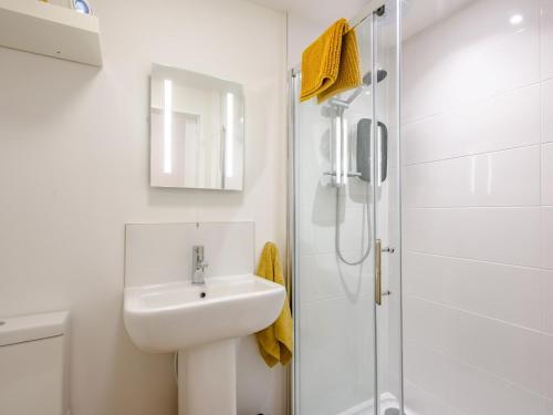 a white bathroom with a sink and a shower at 1 Bed in Dereham 78596 in Bawdeswell
