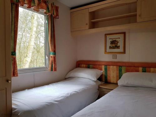 two beds in a small room with a window at Green Shores in Weybourne