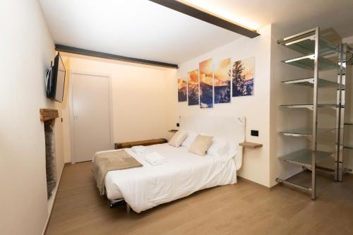 sypialnia z łóżkiem i półką na książki w obiekcie Maison Aubert in Centro Storico w Aoście