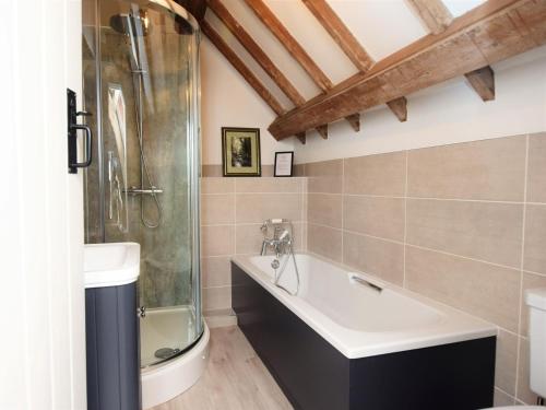 y baño con ducha, bañera y lavamanos. en 2 bed in Brecon 80519, en Llangorse