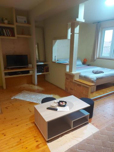 Apartment Slađana في سوبوتيتْسا: غرفة بسرير وطاولة في غرفة