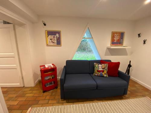a living room with a black couch and a window at Triangel in Schmilau