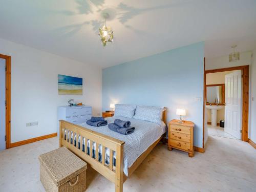 a bedroom with a large bed and a dresser and a bed sidx sidx sidx at 3 Bed in Brecon 83076 in Aber-Brân