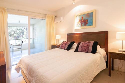 a bedroom with a large bed and a balcony at Oceana Suites Green Park in Punta del Este