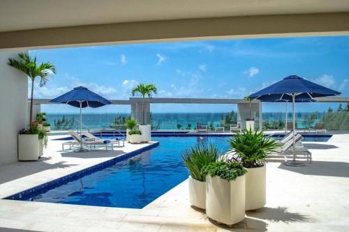 a swimming pool with chairs and umbrellas at 1 Rec. | A pasos de la playa | Roof c/Vista al mar in Playa del Carmen