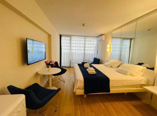 Un dormitorio con una cama grande y una mesa con sillas. en Orbi City apartment with sea view en Batumi