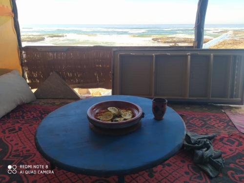 a bowl of food sitting on a table in front of a window at Cave's on to the beach in Douaïra