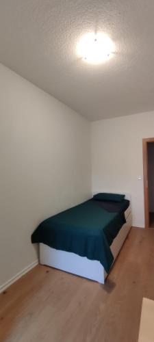 1 dormitorio con 1 cama en una habitación blanca en Komfortables und sauberes Zimmer en Leipzig