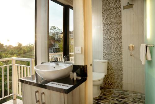 a bathroom with a sink and a toilet at North Wing Canggu Resort in Dalung