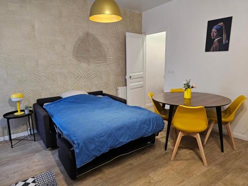 - une chambre avec un lit, une table, une table et des chaises dans l'établissement Petite maison proche du métro, à Bagnolet