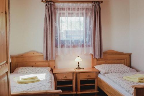 2 camas individuales en una habitación con ventana en Krásný srub na jihu Brna, en Želešice
