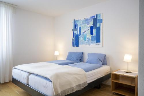 1 dormitorio con 1 cama y una pintura en la pared en Feriensiedlung Trü 9 en Scuol