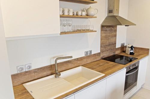 a kitchen with a sink and a stove at Belle Vue - Appartement 2 chambres avec parking in Bordeaux