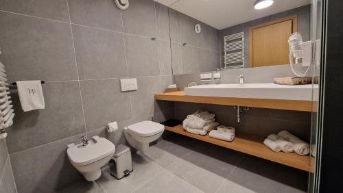 ein Badezimmer mit einem Waschbecken, einem WC und einer Badewanne in der Unterkunft Hotel Sorin MIHAI in Braşov