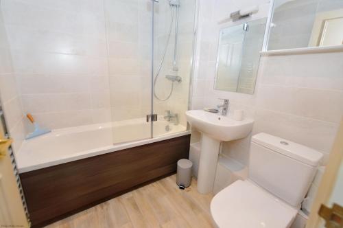a bathroom with a toilet and a sink and a shower at Gull View in Sheringham