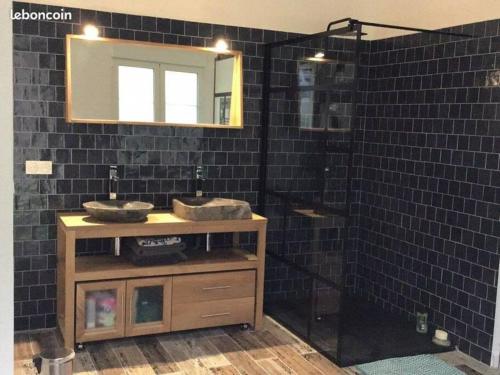 - une salle de bains carrelée de noir avec deux lavabos et un miroir dans l'établissement Appartement plein pied avec terrasse, à Saint-Malo