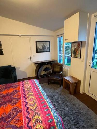 - une chambre avec un lit, une chaise et un piano dans l'établissement Appartement plein pied avec terrasse, à Saint-Malo