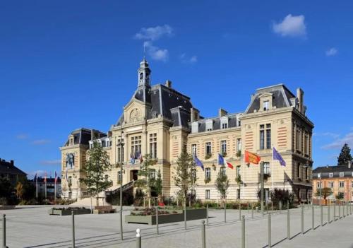 un grand bâtiment avec drapeaux devant lui dans l'établissement App 4 - T3 Calme et Spacieux Hyper Centre 5 min gare, à Évreux