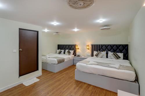 a bedroom with two beds and a mirror at La baga Beach Hotel in Calangute