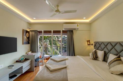 a bedroom with a large bed with a large window at La baga Beach Hotel By Orion Hotels in Calangute