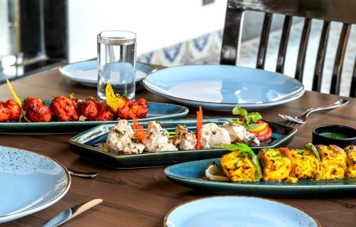 a wooden table with plates of food on it at La baga Beach Hotel in Calangute