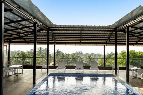 a pool with chairs and tables in a building at La baga Beach Hotel in Calangute