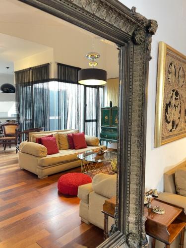 a mirror in a living room with a couch at Ático en Plaza de la Constitución 3 bedrooms in Málaga