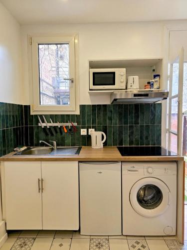 une cuisine avec un lave-linge et un micro-ondes dans l'établissement #3 Maison à 4 minutes du métro et proche de Paris, à Bagnolet