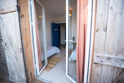 une porte ouverte menant à une chambre dans l'établissement Satya Surf Camp, à Tamaris