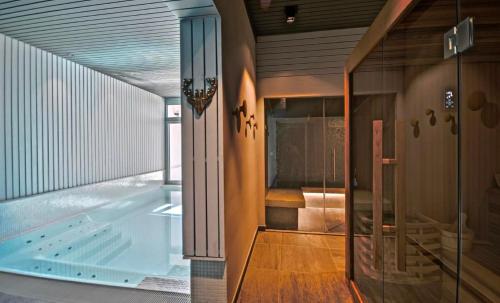 een bad in een kamer met een glazen deur bij Sumptuous Chalet with Breathtaking views by GuestLee in Gryon