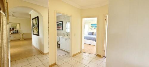 a hallway with a bedroom and a bathroom with a bed at Shelly Beach beachfront apartment in Shelly Beach