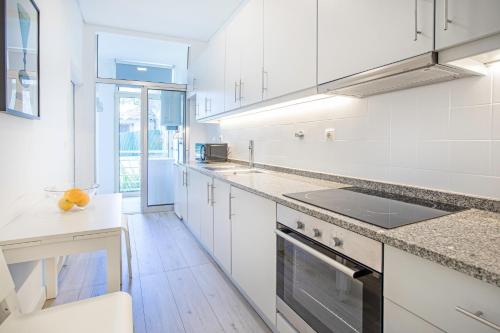 a kitchen with white cabinets and a counter top at Alegria Colour Apartments in Porto