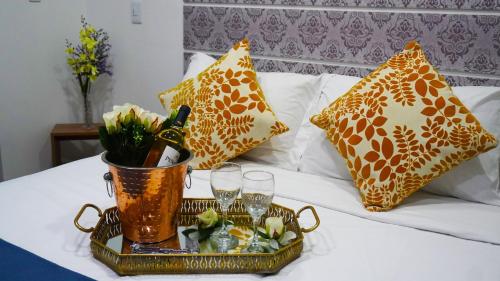 a tray with champagne glasses and flowers on a bed at Hotel Bacata Plaza in Zipaquirá