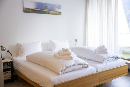 2 toallas están apiladas en una cama en un dormitorio en Chasa Tulai F114 en Scuol