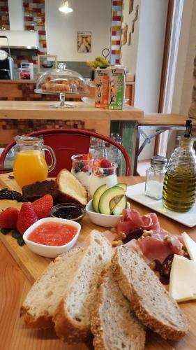 a wooden table topped with sandwiches and fruit and juice at La Casa del Médico Hostería Rural in Urda