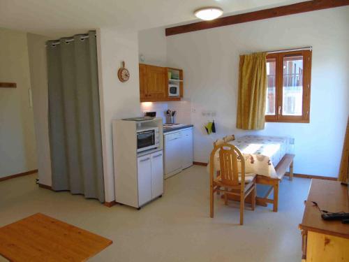 une cuisine avec un réfrigérateur blanc et une table dans l'établissement Appartement 2 pièces + cabine, 6 pers, à Valfréjus, draps inclus, animaux admis - FR-1-561-15, à Valfréjus
