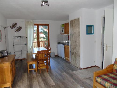 un salon avec une table et une cuisine dans l'établissement Appartement cosy 2 P+Cabine pour 6, proche pistes et commerces, vue Parc Vanoise - FR-1-561-48, à Valfréjus