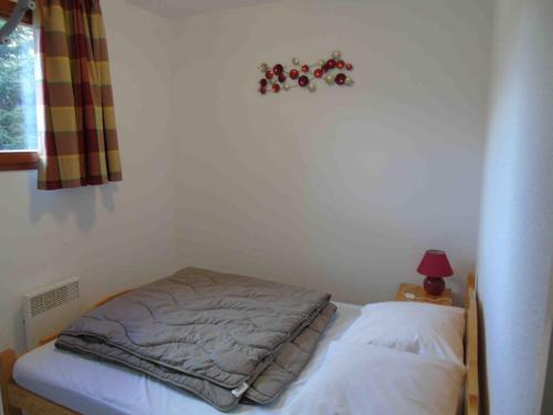 - un petit lit dans une chambre avec une lampe dans l'établissement Appartement cosy à Valfréjus, 200m des pistes, balcon ouest, 6 pers, cuisine équipée, draps inclus - FR-1-561-23, à Valfréjus