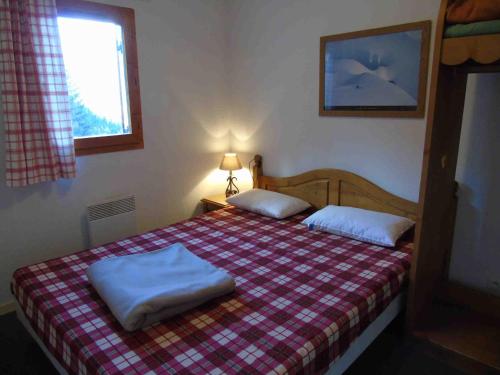 ein Schlafzimmer mit einem Bett mit zwei Kissen darauf in der Unterkunft Appartement Valfréjus, 3 pièces, 8 personnes - FR-1-561-55 in Valfréjus