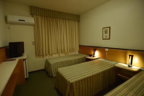 a hotel room with two beds and a television at Park Hotel Morotin in Santa Maria