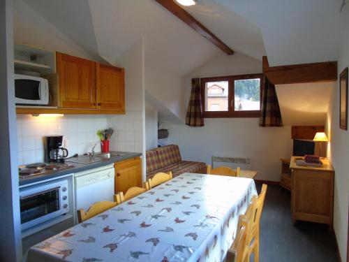une cuisine et une salle à manger avec une table et des chaises dans l'établissement Appartement Valfréjus 8 pers, cuisine équipée, 2 sdb, animaux admis - FR-1-561-27, à Valfréjus