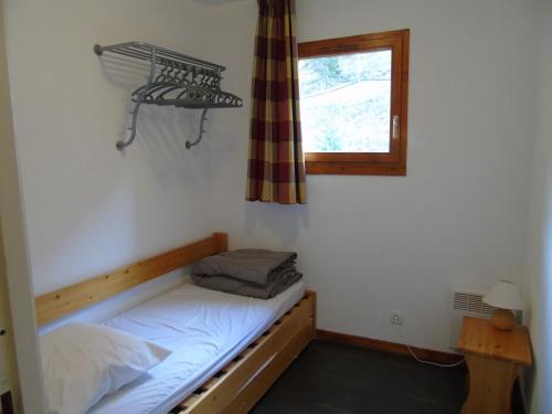 une petite pièce avec un lit et une fenêtre dans l'établissement Appartement Valfréjus 8 pers, cuisine équipée, 2 sdb, animaux admis - FR-1-561-27, à Valfréjus