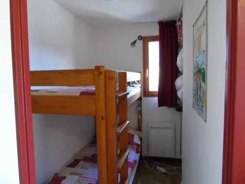 Cette petite chambre comprend des lits superposés et une fenêtre. dans l'établissement Appartement Valfréjus, 3 pièces, 6 personnes - FR-1-561-28, à Valfréjus